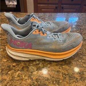 Hoka Clifton 9 Light Blue Running Shoe with Orange and Pink Accents